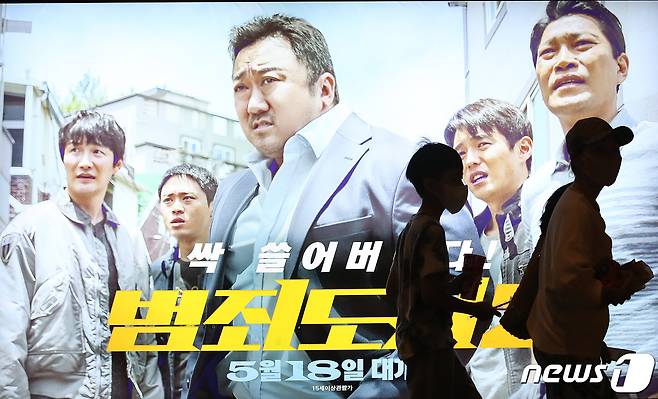 12일 서울 CGV용산아이파크몰에서 ‘범죄도시2’ 포스터 앞으로 영화팬들이 지나가고 있다. 영화 '범죄도시2'(감독 이상용)가 3일 연속 박스오피스 1위를 기록한 가운데, 천만 관객을 돌파했다. 12일 영화진흥위원회 영화관 입장권 통합전산망 집계에 따르면 '범죄도시2'는 지난 11일 33만9167명의 관객을 동원하며, 박스오피스 1위에 올랐다. 또한 누적관객수는 1017만2349명으로 집계되면서 대한민국 영화 사상 역대 28번째 천만 영화이자, 팬데믹 이후 최초 천만 영화로 등극했다. 2022.6.12/뉴스1 © News1 임세영 기자