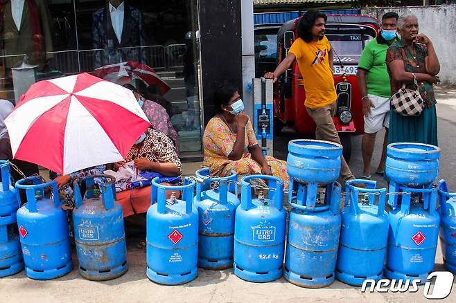 지난 15일(현지시간) 스리랑카 수도 콜롬보의 시민들이 액화석유가스(LPG)를 리필하기 위해 대기 중이다. 2022.06.15 © AFP=뉴스1 © News1 정윤미 기자