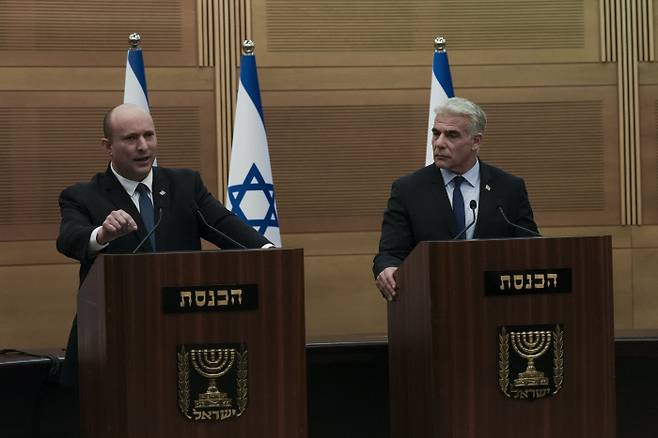 “여기까지” 이스라엘 나프탈리 베네트 총리(왼쪽)와 야이르 라피드 외무장관이 20일(현지시간) 예루살렘 의회에서 연정 해산을 발표하고 있다. 예루살렘 | AP연합뉴스