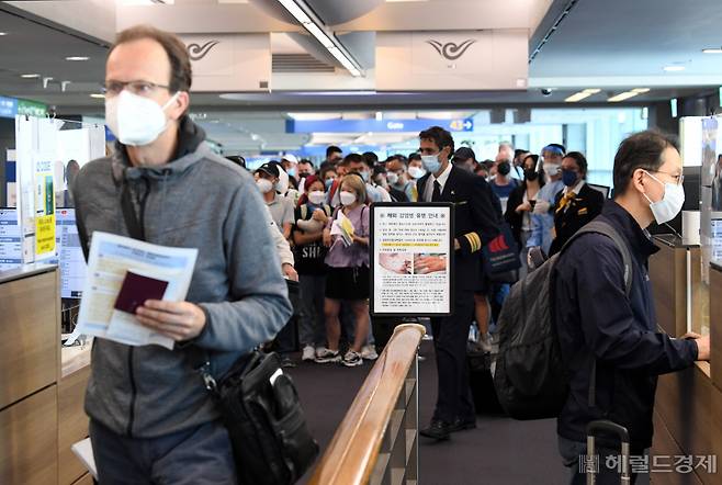 5월 27일 오전 인천국제공항 제1터미널 입국장에 독일 프랑크푸르트와 우즈베키스탄발 탑승객들이 검역을 받기 위해 대기하고 있다. 승객들 앞에는 원숭이두창 관련 안내문이 세워져 있다. [영종도=박해묵 기자]