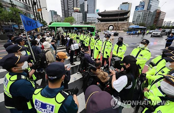 "탈시설 조례 제정" 횡단보도에 멈춰선 장애인단체 (서울=연합뉴스) 임헌정 기자 = 전국장애인차별철폐연대 관계자들이 15일 서울 중구 숭례문에서 서울시의회까지 '탈시설 조례 제정'을 촉구하며 행진을 하던 중 횡단보도에 멈춰 서 시위를 하고 있다. 2022.6.15 kane@yna.co.kr
