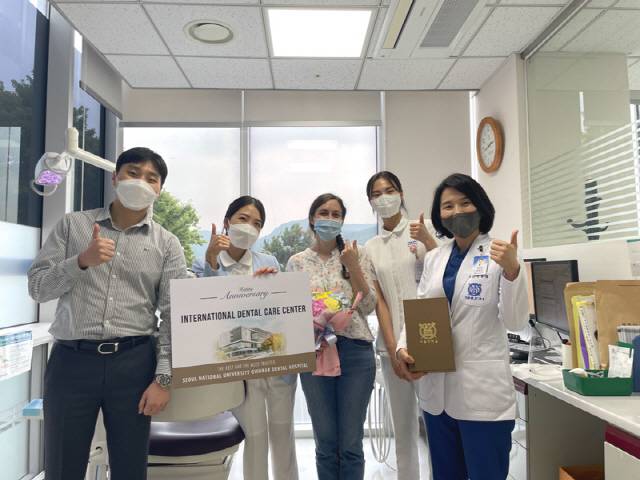 외국인 환자에게 외국인 전담팀이 기념품을 전달하고 있다. 오른쪽은 치주과 김윤정 교수.