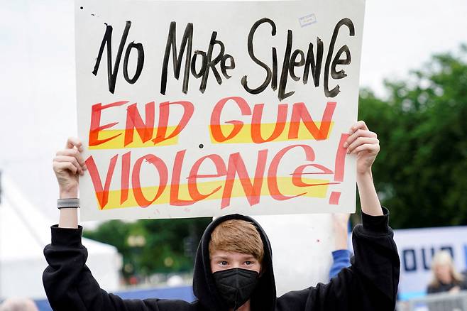 미국 워싱턴DC에서 11일(현지시간) 의회에 총기 규제 관련 법안 처리를 촉구하는 시위 참가자가 '총기 폭력을 끝내라'라고 적힌 팻말을 들고 있다. /연합뉴스
