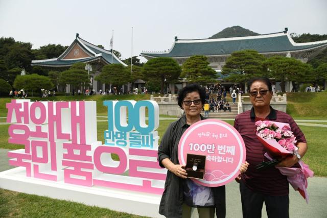 청와대를 방문한 100만 번째 관람객으로 선정된 김영순(72·왼쪽)씨가 기념품으로 받은 대통령 기념 시계와 꽃다발을 들고 기념촬영을 하고 있다. 문화재청 제공