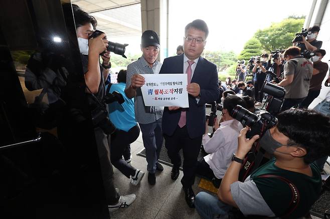 Kim Ki-yun, the attorney representing the bereaved family, holds a press conference outside the Seoul prosecutors’ office on Wednesday. On the left is the official’s older brother, Lee Rae-jin. (Yonhap)