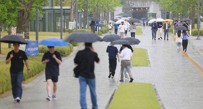 지난 9일 오후 서울 서대문구 연세대학교에서 학생과 시민들이 우산을 쓰고 이동하고 있다. [사진 출처 = 연합뉴스]
