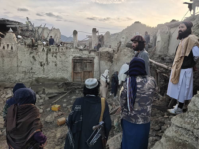 2일(현지시간) 아프가니스탄 남동부 파크티카주에서 발생한 강진으로 가옥들이 파괴된 채 주민들이 잔해 주변을 바라보고 있다. 연합뉴스·AP