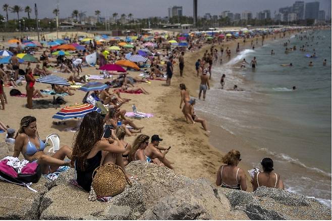 [바르셀로나=AP/뉴시스] 지난 19일(현지시간) 스페인 바르셀로나의 한 해변에서 사람들이 더위를 식히며 휴가를 즐기고 있다. 2022.06.22.  *재판매 및 DB 금지
