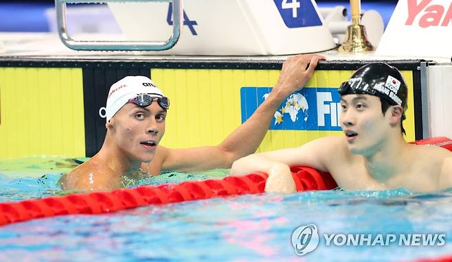 세계선수권 자유형 200m 결승 기록 확인하는 황선우 (부다페스트 신화=연합뉴스) 황선우(오른쪽)가 20일(현지시간) 헝가리 부다페스트에서 열린 2022 국제수영연맹(FINA) 세계선수권대회 남자 자유형 200m 결승전을 마친 후 기록을 확인하고 있다. 이날 황선우는 1분44초47의 한국 신기록을 세우고 다비드 포포비치(왼쪽·루마니아·1분43초21)에 이어 2위로 레이스를 마쳐 은메달을 목에 걸었다. 2022.6.21 leekm@yna.co.kr