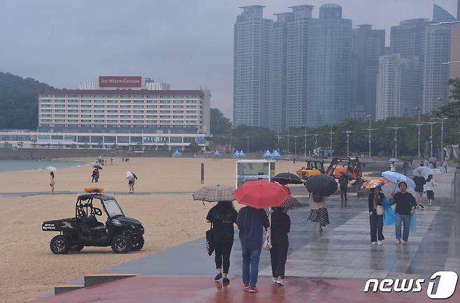 부산 해운대해수욕장을 찾은 관광객들이 우산을 쓰고 빗속을 걷고 있다. 2019.6.26/뉴스1 © News1