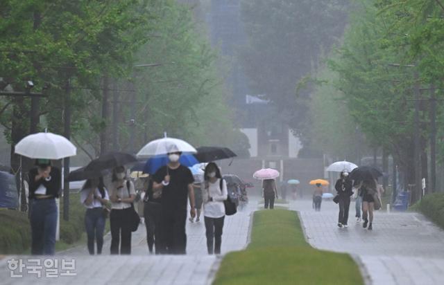 장마가 시작된 24일 서울 서대문구 연세대에서 우산을 쓴 시민들이 걷고 있다. 최주연 기자