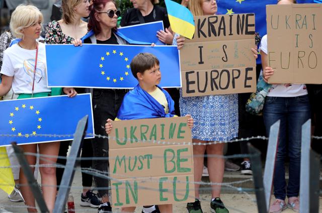 유럽연합(EU) 정상회의가 열리는 벨기에 브뤼셀 EU 본부 앞에서 23일 우크라이나의 EU 가입 지지자들이 시위하고 있다. 브뤼셀=AP 뉴시스