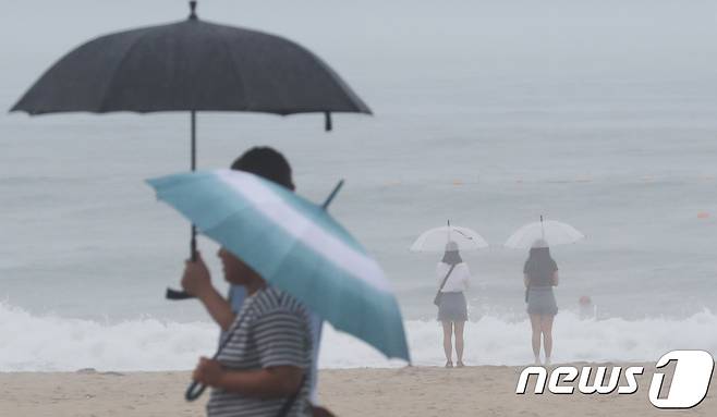 부산 해운대해수욕장을 찾은 관광객들이 우산을 쓰고 바다를 바라보고 있다. 2018.6.28/뉴스1 © News1