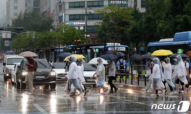 장맛비가 내리는 23일 오후 서울 세종대로사거리 횡단보도에서 우산을 쓰고 우비를 입은 시민들이 발걸음을 재촉하고 있다. 2022.6.23/뉴스1 © News1 박세연 기자
