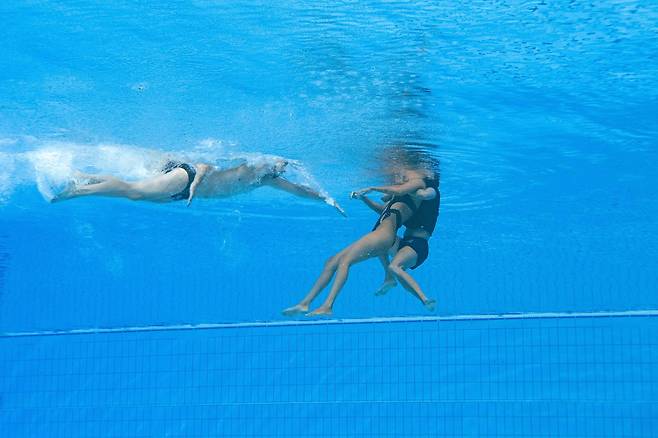 미국 아티스틱스위밍 알바레스가 물속에서 의식을 잃자 푸엔테스 코치가 물속에 뛰어 들어 구조하고 있다. [AFP=연합뉴스]