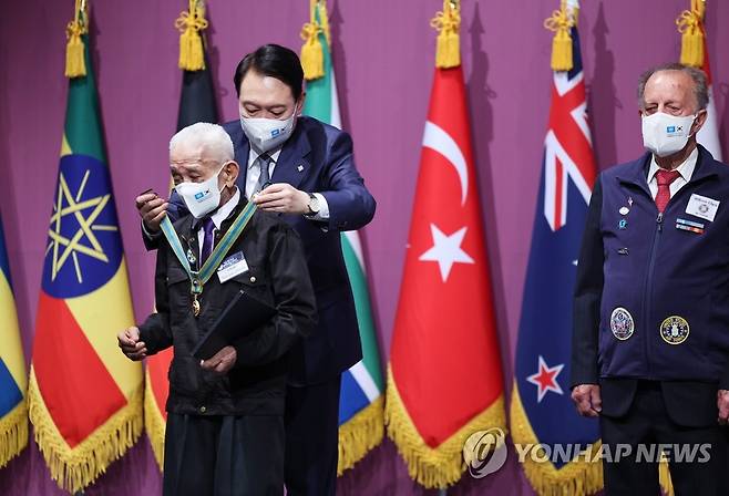 유엔 참전용사에 평화의 사도 메달 수여하는 윤석열 대통령 (서울=연합뉴스) 안정원 기자 = 윤석열 대통령이 6ㆍ25전쟁 72주년을 하루 앞둔 24일 서울 중구 신라호텔에서 열린 국군 및 유엔군 참전유공자 초청 오찬에서 베니토 주니오 카마초(필리핀. 당시 육군 제2대대 전투단 훈련병) 참전용사에게 평화의 사도 메달을 수여하고 있다. 오른쪽은 윌리엄 길버트 클라크(미국. 당시 공군 하사).  2022.6.24 jeong@yna.co.kr