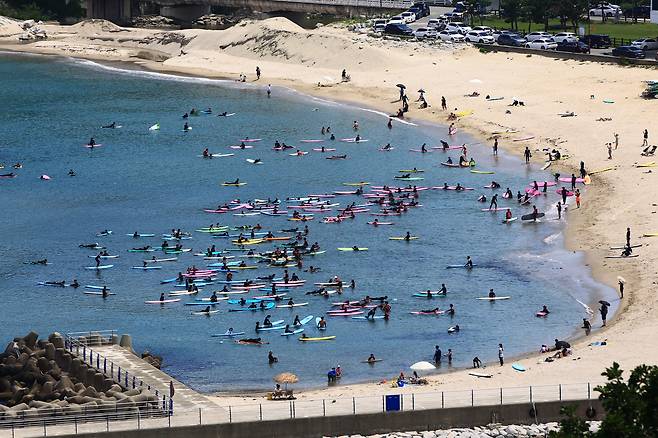동해안 지방의 낮 기온이 30도를 훌쩍 넘어선 무더위가 이어진 25일 양양지역 한 해변이 서퍼들로 붐비고 있다. [연합]
