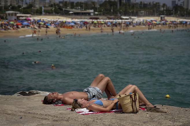 지난 19일(현지시간) 폭염이 찾아든 스페인 바로셀로나의 한 해변에서 한 쌍의 남녀가 더위를 식히고 있다. [AP]
