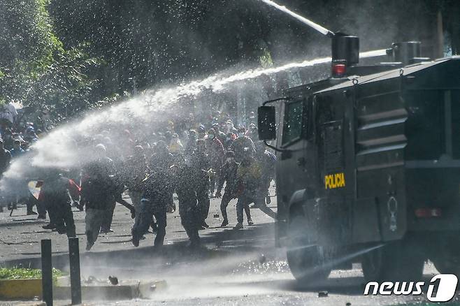 지난 22일(현지시간) 에콰도르 키토에서 진압 경찰이 기름값 인상에 항의하는 시위대를 향해 물대포를 쏘고 있다. © AFP=뉴스1 © News1 우동명 기자