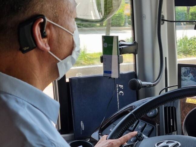 지난 3일 김연학 버스기사가 뇌파를 측정하는 이어셋을 착용하고 주행을 하고 있다. 뇌파를 측정하는 차량용 헬스케어 기술이 적용돼 졸음이 오거나 멍한 상태가 되면 스마트폰 화면이 빨간색으로 변하고, 이어셋에서 경고음이 나온다.