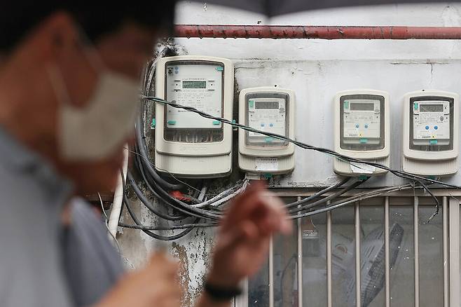 한국전력이 7월부터 전기요금을 킬로와트시(㎾h)당 5원 올린다고 발표한 27일 오후 서울 시내의 전기계량기 앞을 시민들이 지나가고 있다. 연합뉴스