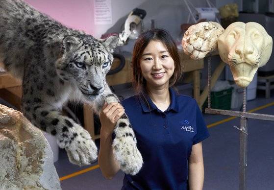 서울대공원 윤지나 박제사가 최근 마무리 작업을 하고 있는 눈표범(설표) 박제와 포즈를 취했다.
