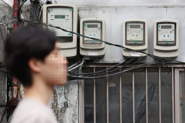 27일 오후 서울 시내의 전기계량기 앞을 한 시민이 지나가고 있다. 연합뉴스