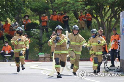 (제주=연합뉴스) 지난달 24일 제주소방교육대에서 열린 소방기술경연대회 속도 방수 부문에 참가한 소방관들이 소방 호스를 들고 달리고 있다. 2022.5.24 [제주소방안전본부 제공. 재판매 및 DB 금지]