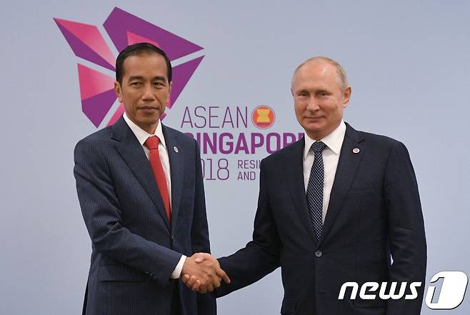 블라디미르 푸틴 러시아 대통령이 지난 2018년 11월14일(현지시각) 싱가포르에서 열리는 아세안 정상회의에서 조코 위도도 인도네시아 대통령를 만나 악수를 하고 있다. 2018.11.14 © AFP=뉴스1 © News1 우동명 기자