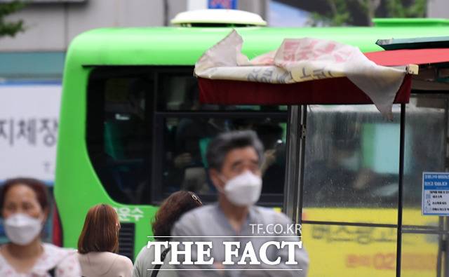 한 가게에 걸린 현수막이 강풍에 뒤집혀 있다.