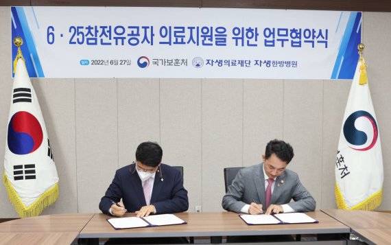 6·25 참전유공자 의료지원 업무협약식에서 자생의료재단 신민식 사회공헌위원장(왼쪽)과 박민식 국가보훈처장이 협약서에 서명하고 있다. 자생한방병원 제공.