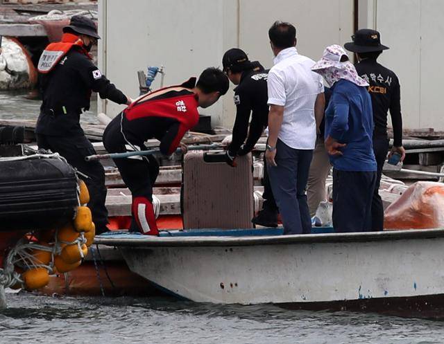 28일 오후 전남 완도군 신지면 송곡선착장 방파제로부터 80m 지점 가두리 양식장 아래에서 실종된 조유나(10) 양 가족의 차량으로 추정되는 아우디 승용차가 발견됐다. 경찰이 수중에 있는 차량 내에서 케리어를 건져 올리고 있다. 연합뉴스