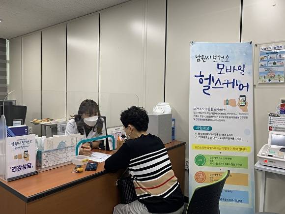 전라북도 남원시보건소에서 한 시민이 모바일 헬스케어에 대한 설명을 듣고있다.[사진=남원시청]