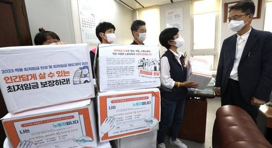 민주노총 근로자위원들이 28일 오후 세종시 정부세종청사 최저임금위원회 회의실에서 열린 제7차 전원회의에 앞서 울산지역본부 노동자들이 보낸 최저임금 설문 및 희망 엽서 2만여장을 박준식 최저임금위원회 위원장에게 전달하고 있다. 뉴스1