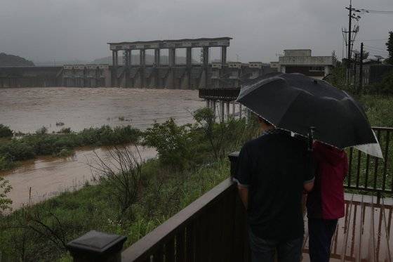 장마전선 영향으로 북한 지역에 집중호우가 지속되는 가운데 28일 경기도 연천군 군남홍수조절댐에서 주민들이 방류되는 임진강 상류의 물을 바라보고 있다.   비무장지대(DMZ) 임진강 필승교 수위는 이날 오전 1시 30분에 '비홍수기 인명 대피' 기준인 2ｍ를 넘어섰으며, 오전 11시에 3ｍ로 상승했다. 이에 행정안전부는 접경지역 수위 상승에 대한 안전관리를 관계 기관에 지시했다. 연합뉴스