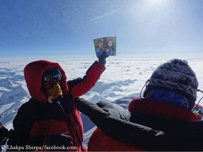 2017년 에베레스트 등정 당시 두 딸의 사진을 정상에서 들고 있는 락파 셰르파. 사진 락파 셰르파.