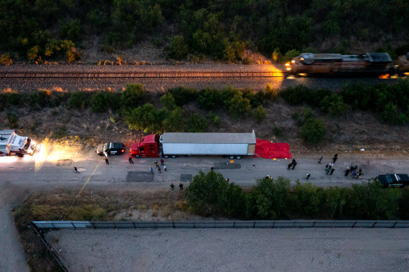 미국 텍사스주 사법당국 조사요원들이 27일(현지시간) 불법 이민을 희망하다 46명 이상이 주검으로 발견된 트럭 주변을 살펴보고 있다. 이 트럭은 샌안토니오 사우스웨스트 사이드의 철로 변에 주차된 채로 오후 6시쯤 발견됐다.샌안토니오 AFP 연합뉴스