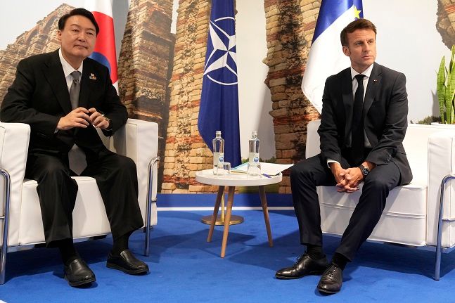 대서양조약기구(NATO·나토) 정상회의에 참석한 윤석열 대통령이 29일(현지시간) 스페인 마드리드 이페마(IFEMA)에서 에마뉘엘 마크롱 프랑스 대통령과 만나 자리에 앉아 있다. ⓒAP/뉴시스