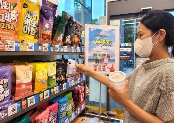 이마트24에서 한 고객이 해외여행 경품 이벤트 중인 파우치 음료를 살펴보고 있다. 이마트24 제공.