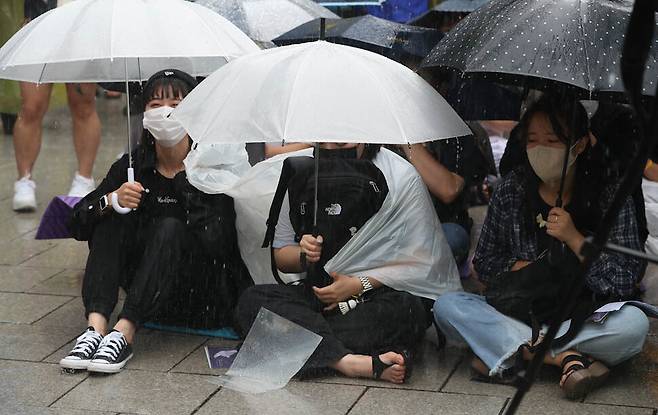 장맛비가 내린 29일 오후 서울 종로구 옛 일본대사관 앞 평화로에서 우산을 받쳐든 시민들이 ‘정기 수요시위’에 참석하고 있다. 김정효 기자