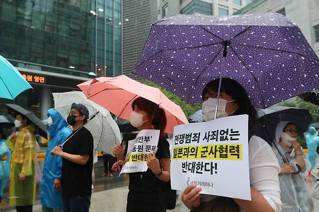 장맛비가 내린 29일 오후 서울 종로구 옛 일본대사관 앞 평화로에서 열린 ‘제1550차 일본군 성노예제 문제 해결을 위한 정기 수요시위’ 참가자들이 일본과의 군사협력에 반대한다는 내용의 손팻말을 들고 있다. 김정효 기자