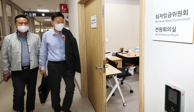 ▲ 29일 오후 세종시 정부세종청사 최저임금위원회 회의실에서 열린 제8차 전원회의에 사용자위원인 류기정 한국경영자총협회 전무(오른쪽)와 근로자위원인 이동호 한국노총 사무총장이 회의실로 향하고 있다. 사진=연합뉴스