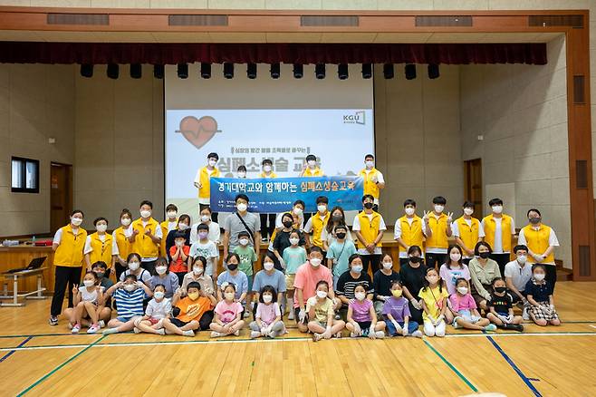 [수원=뉴시스] 29일 경기 수원시 영통구 매여울초등학교 강당에서 진행된 심폐소생술 교육프로그램에 참여한 학생과 학부모들이 이번 교육에서 강사로 활동한 경기대 재학생들과 함께 기념사진을 찍고 있다. 2022.06.29. (사진=경기대 제공) *재판매 및 DB 금지