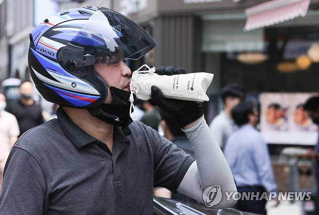 캠페인에서 받은 얼음물 마시는 이동노동자 (서울=연합뉴스) 서대연 수습기자 = 한 이동노동자가 22일 오전 서울 종로구 젊음의거리에서 진행된 '이동노동자를 위한 생수나눔 캠페인'에서 받은 얼음물을 마시고 있다.
    캠페인은 여름철 폭염 속 일하는 이동노동자들에게 7만5천여병의 생수를 나눠주는 방식으로, 서울시와 서울시노동권익센터 등 민·관이 함께 진행한다. 2022.6.22 dwise@yna.co.kr