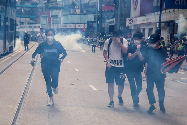 지난 2020년 5월 24일 홍콩 경찰들이 반정부 시위대를 향해 최루탄을 쏘고 있다. (사진=AFP)