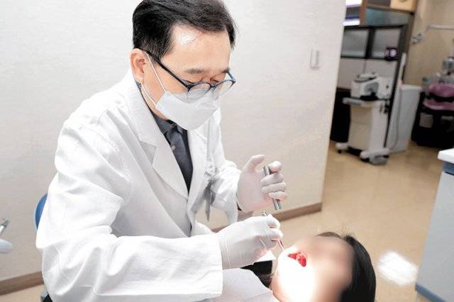 경희대치과병원 구강내과 전양현 교수가 환자의 입안 상태를 살피기 위해 구강진찰을 하고 있다. 경희대치과병원 제공