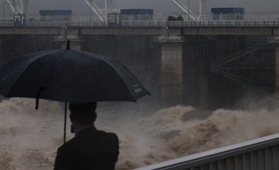 30일 하남시 팔당댐 근처에서 한 시민이 집중호우로 방류 중인 댐을 보고 있다. 연합뉴스