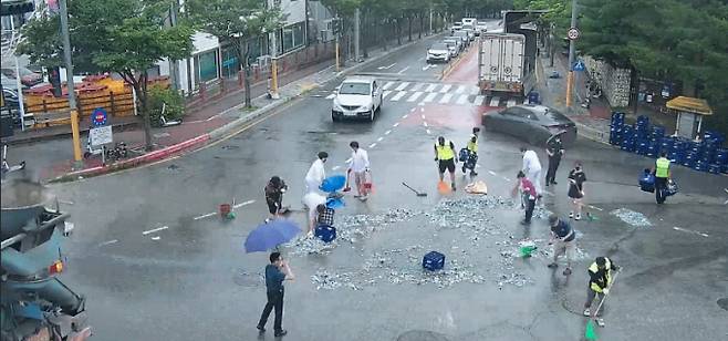 시민들이 힘을 모아 차량에서 떨어진 파편을 정리하고 있다. /사진=춘천시 제공