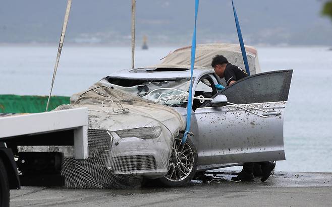 29일 오전 전남 완도군 신지면 송곡선착장 인근 방파제에서 경찰이 10ｍ 바닷속에 잠겨있는 조유나(10)양 가족의 차량을 인양하고 시신을 수습한 뒤 내부를 조사하고 있다. 경찰은 실종된 조양의 가족과 차량을 찾기 위해 수중 수색하다 전날 가두리양식장 아래에 잠겨있는 차량을 발견했다. [연합]