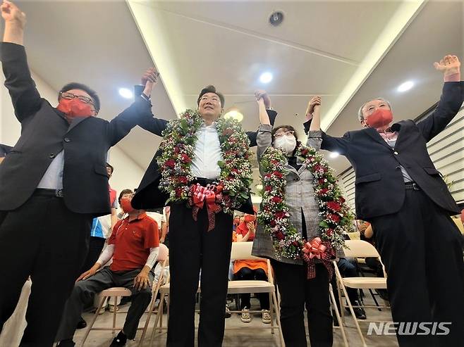 [원주=뉴시스] 이덕화 기자 = 원강수 국민의힘 원주시장 당선인이 축하 꽃다발을 받은 후 당원·지지자들의 환호와 박수를 받으며 두팔을 들고 승리를 자축하고 있다. 2022.06.02. wonder8768@newsis.com